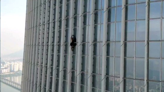 영국인 남성이 12일 오전 서울 송파구 롯데월드타워를 무단으로 등반하고 있다. [송파소방서]